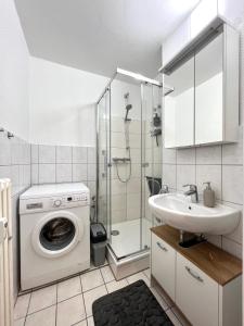 哈廷根Stilvolles Apartment mit ländlichem Ausblick的一间带洗衣机和水槽的浴室