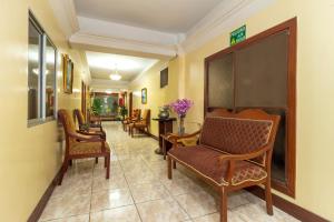 瓜亚基尔马雷贡酒店的一间设有桌椅的等候室和走廊