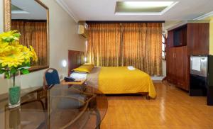 瓜亚基尔马雷贡酒店的酒店客房设有一张床铺和一张玻璃桌