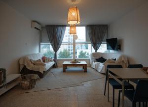 内坦亚Appartement cosy sur Netanya的客厅配有两张沙发和一张桌子