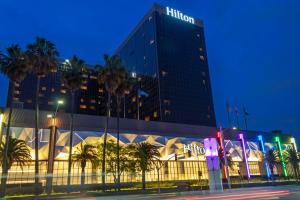 洛杉矶洛杉矶机场希尔顿酒店的一家在晚上拥有棕榈树的希尔顿酒店