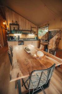 PenrhôsCosy Forest Lodge的厨房里配有一张大木桌和椅子