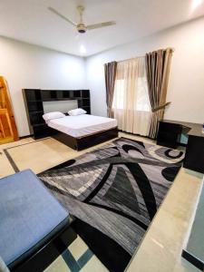 BālākotTwo-Bedrooms Suite At Country Club Balakot的卧室配有一张床,地板上铺有地毯