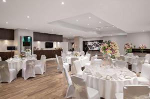 伦敦希尔顿伦敦肯辛顿酒店的宴会厅配有白色的桌子和白色的椅子