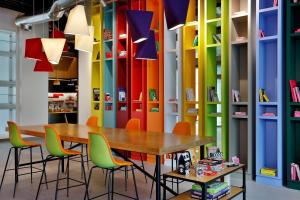 迪拜Aloft Al Mina, Dubai Jumeirah的客房设有桌椅和色彩缤纷的墙壁。
