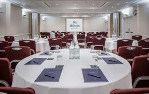 伦敦希尔顿伦敦尤斯顿酒店的一间会议室,配有白色的桌椅