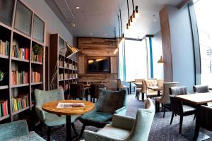 曼彻斯特双树希尔顿曼切斯特皮卡迪利酒店的一间带桌椅和书架的餐厅