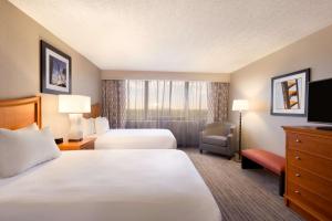 奥兰多Embassy Suites by Hilton Orlando International Drive ICON Park的酒店客房设有两张床和电视。