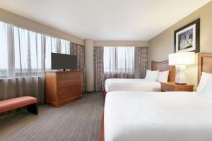 奥兰多Embassy Suites by Hilton Orlando International Drive ICON Park的酒店客房设有两张床和一台平面电视。
