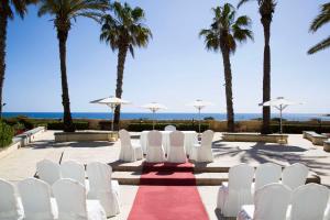 圣朱利安斯马耳他希尔顿酒店的婚礼过道,带白色椅子和棕榈树