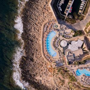 圣朱利安斯马耳他希尔顿酒店的享有游泳池的顶部景色,位于一个毗邻大海的度假胜地