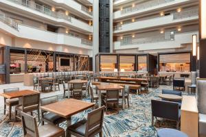 滨海城Embassy Suites by Hilton Monterey Bay Seaside的大楼内带桌椅的餐厅
