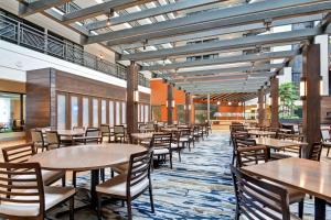 布卢明顿Embassy Suites by Hilton Minneapolis Airport的大楼内带桌椅的用餐区