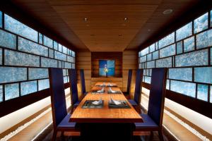 名古屋名古屋希尔顿酒店的一间带长桌和蓝色椅子的用餐室