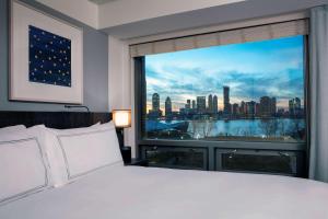 纽约Conrad New York Downtown的一间卧室设有大窗户,享有城市景观