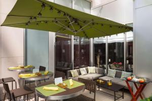 纽约纽约曼哈顿市中心东希尔顿花园酒店的一个带桌子和绿色遮阳伞的庭院