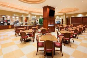 诺曼Embassy Suites by Hilton Norman Hotel & Conference Center的一间带桌椅的餐厅和一间酒吧
