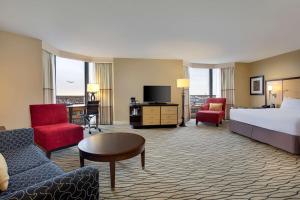 罗斯芒特芝加哥奥黑尔希尔顿罗斯蒙特酒店的酒店客房配有一张床、一张沙发和椅子。