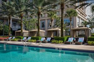 奥兰多奥兰多华尔道夫度假村及酒店的酒店游泳池设有躺椅和棕榈树