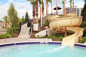 奥兰多Signia by Hilton Orlando Bonnet Creek的棕榈树度假村的游泳池滑梯