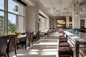 奥兰多Signia by Hilton Orlando Bonnet Creek的用餐室设有桌椅和窗户。
