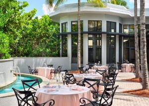 棕榈滩花园棕榈滩花园希尔顿逸林酒店的大楼前带桌椅的天井