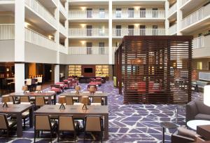 费城Embassy Suites by Hilton Philadelphia Airport的餐厅的 ⁇ 染,配有桌椅