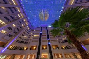 布拉格布拉格希尔顿酒店的一座拥有蓝色天花板和棕榈树的大型建筑