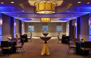 费城DoubleTree by Hilton Hotel Philadelphia Center City的宴会厅配有桌椅和吊灯