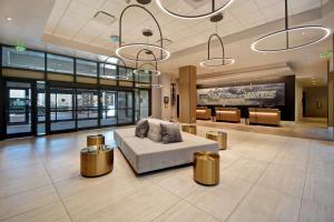 卡瑞Embassy Suites by Hilton Raleigh Durham Research Triangle的一个带沙发和两个金凳的大堂