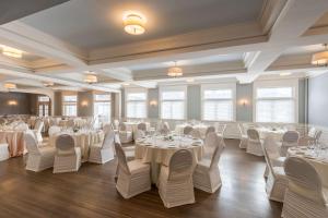 罗切斯特斯特拉撒伦 - 希尔顿逸林酒店 的宴会厅配有白色的桌椅