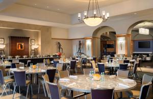 圣克拉拉希尔顿圣塔克拉酒店的一间带桌椅和吊灯的用餐室