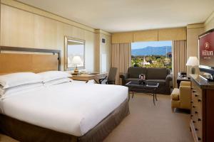 圣克拉拉希尔顿圣塔克拉酒店的一间带大床的卧室和一间客厅