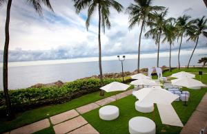 圣胡安康达多广场希尔顿酒店的庭院配有白色桌椅,棕榈树