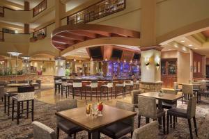 圣马科斯Embassy Suites by Hilton San Marcos Hotel Conference Center的一间带桌椅的餐厅和一间酒吧