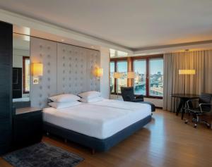 斯德哥尔摩斯德哥尔摩斯拉森希尔顿酒店的酒店客房设有一张大床、一张桌子和椅子。