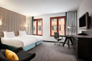 斯德哥尔摩斯德哥尔摩斯拉森希尔顿酒店的配有一张床和一张书桌的酒店客房