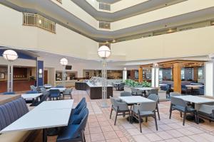 坦帕Embassy Suites by Hilton Tampa USF Near Busch Gardens的自助餐厅内带桌椅的餐厅