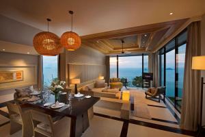 塔林甘海滩Conrad Koh Samui Residences的一间带餐桌的客厅和一间客厅。