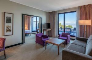 埃维昂莱班希尔顿伊凡乐班酒店的客厅配有紫色家具和大窗户
