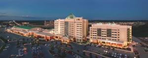 罗杰斯西北阿肯色州希尔顿合博套房水疗酒店&会展中心的享有带停车场的大型建筑的顶部景色
