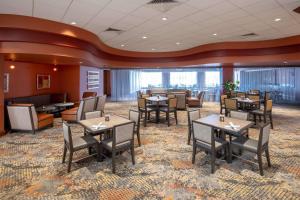 罗杰斯西北阿肯色州希尔顿合博套房水疗酒店&会展中心的一间在房间内配有桌椅的餐厅