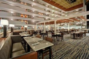 奥马哈Embassy Suites by Hilton Omaha Downtown Old Market的一间在房间内配有桌椅的餐厅