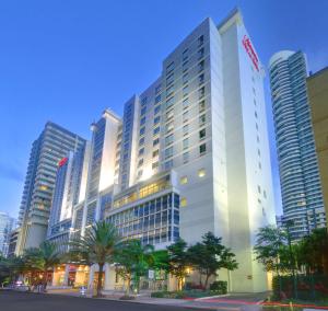 迈阿密希尔顿汉普顿酒店及套房迈阿密市中心/布里克尔的一座高大的白色建筑,前面有棕榈树