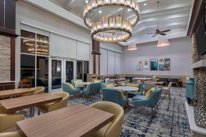 亚特兰大Homewood Suites by Hilton Atlanta Perimeter Center的一间带桌椅和吊灯的餐厅