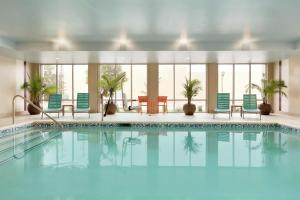 斯蒂尔沃特斯蒂尔沃特希尔顿欣庭套房酒店的大楼内带蓝色椅子的游泳池