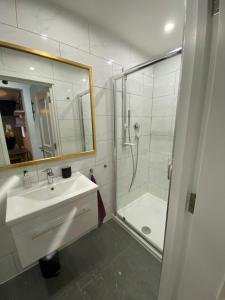 伦敦Stylish 1-bed studio的白色的浴室设有水槽和淋浴。