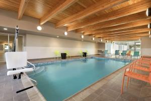 罗斯维尔Home2 Suites by Hilton Roseville Minneapolis的大楼内带桌椅的大型游泳池
