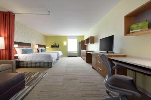 罗斯维尔Home2 Suites by Hilton Roseville Minneapolis的配有一张床和一张书桌的酒店客房