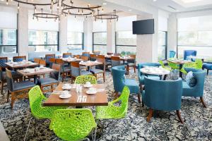 阿林顿Hilton Garden Inn Dallas/Arlington South的用餐室设有桌椅和窗户。
